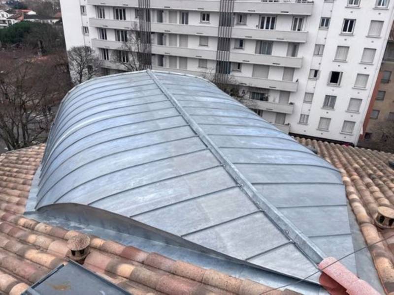 Rénovation complète d'une lucarne cintrée en zinc avec une grue à Toulouse en Haute Garonne